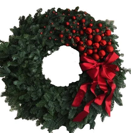 Wieniec świąteczny z zielonych gałązek z czerwonymi bombkami i kokardą – dekoracja bożonarodzeniowa na drzwi