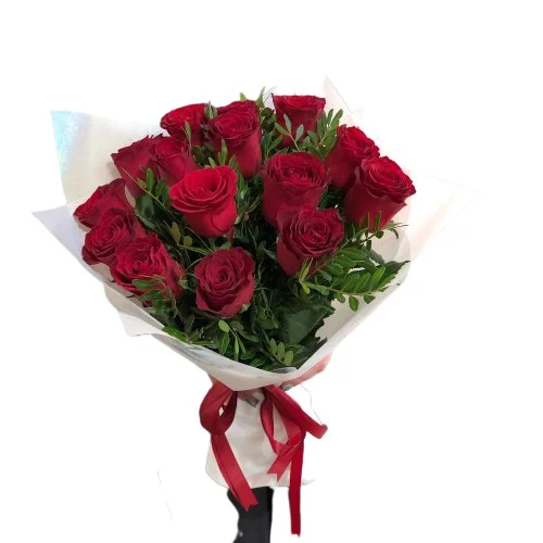 Bukiet róż z klasycznymi czerwonymi różami i zielenią dekoracyjną w białym papierze