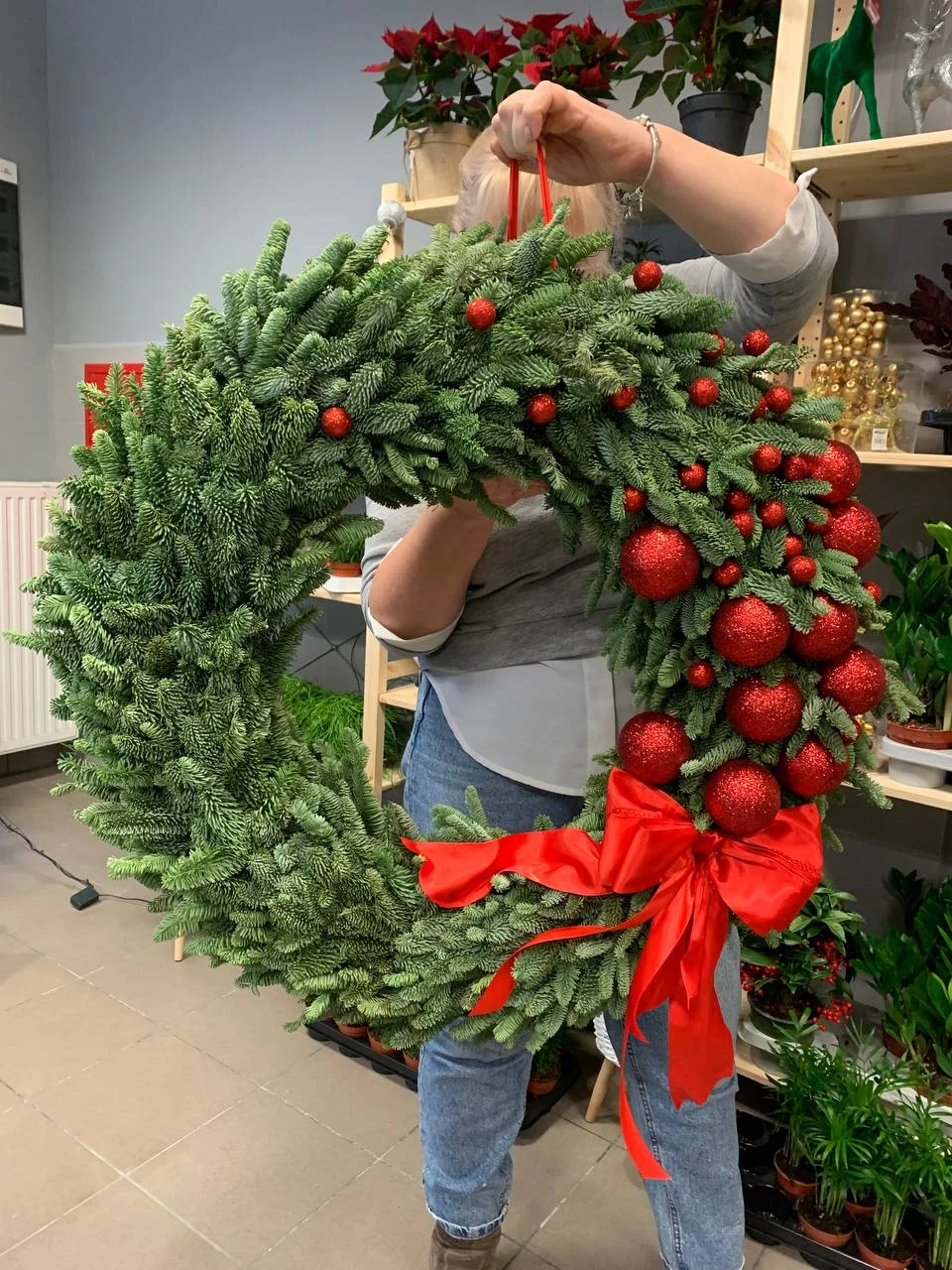 Duży wieniec świąteczny z gałązek jodły z czerwonymi bombkami i kokardą – ręcznie wykonana dekoracja bożonarodzeniowa