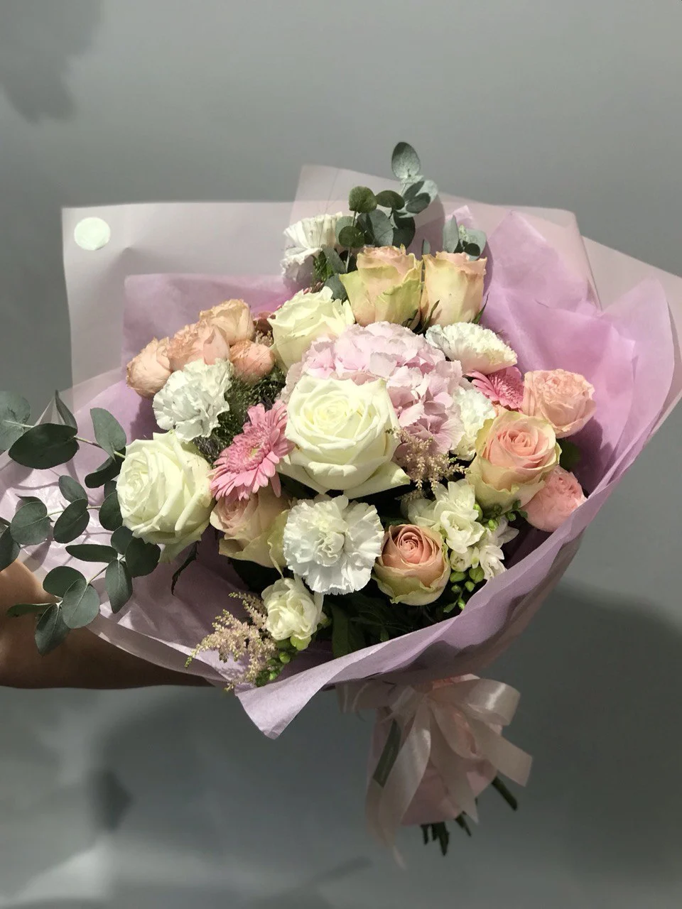 Bukiet róż i goździków w pastelowych odcieniach z jasnoróżowym papierem