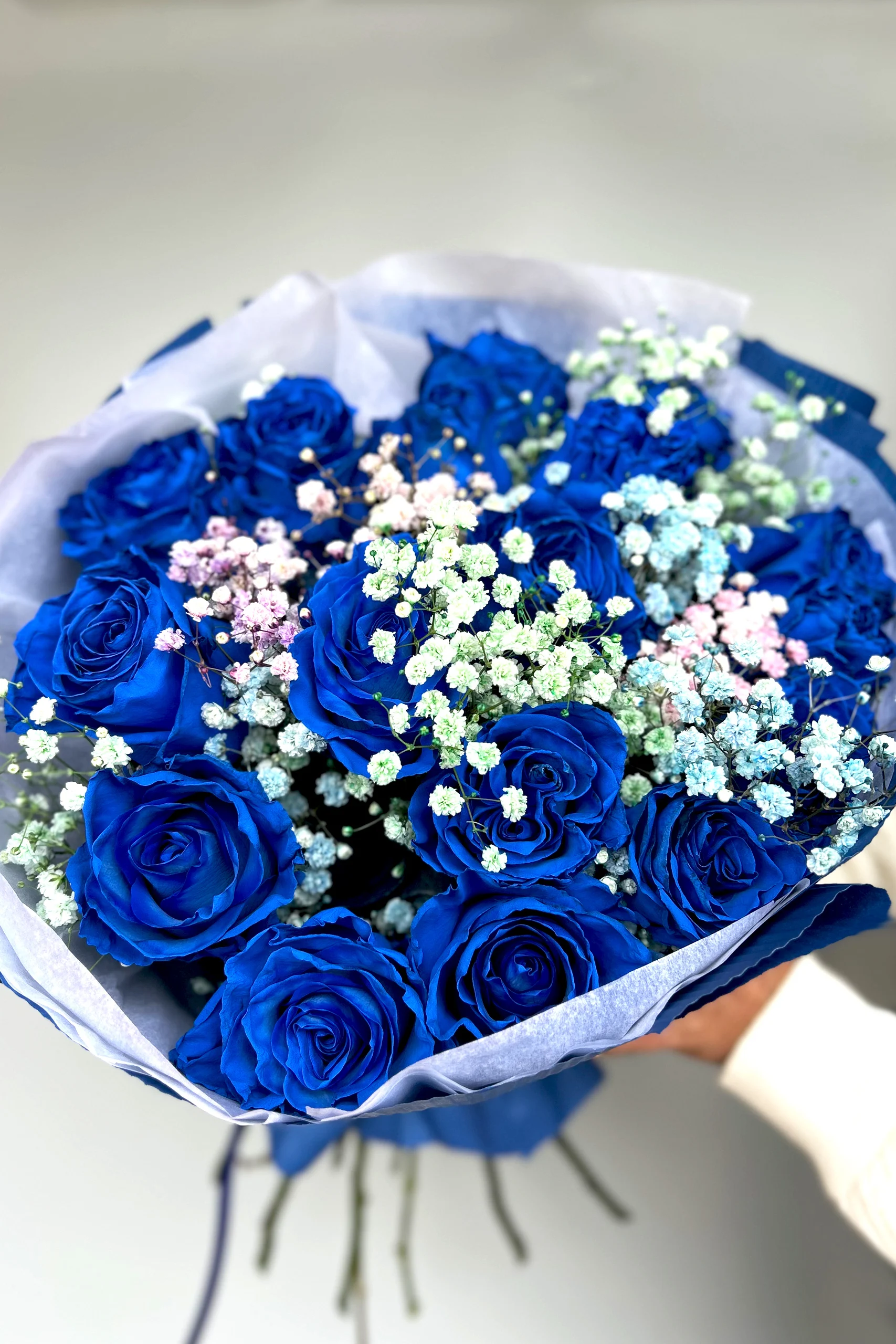 Bukiet niebieskich róż w otoczeniu drobnych białych kwiatów