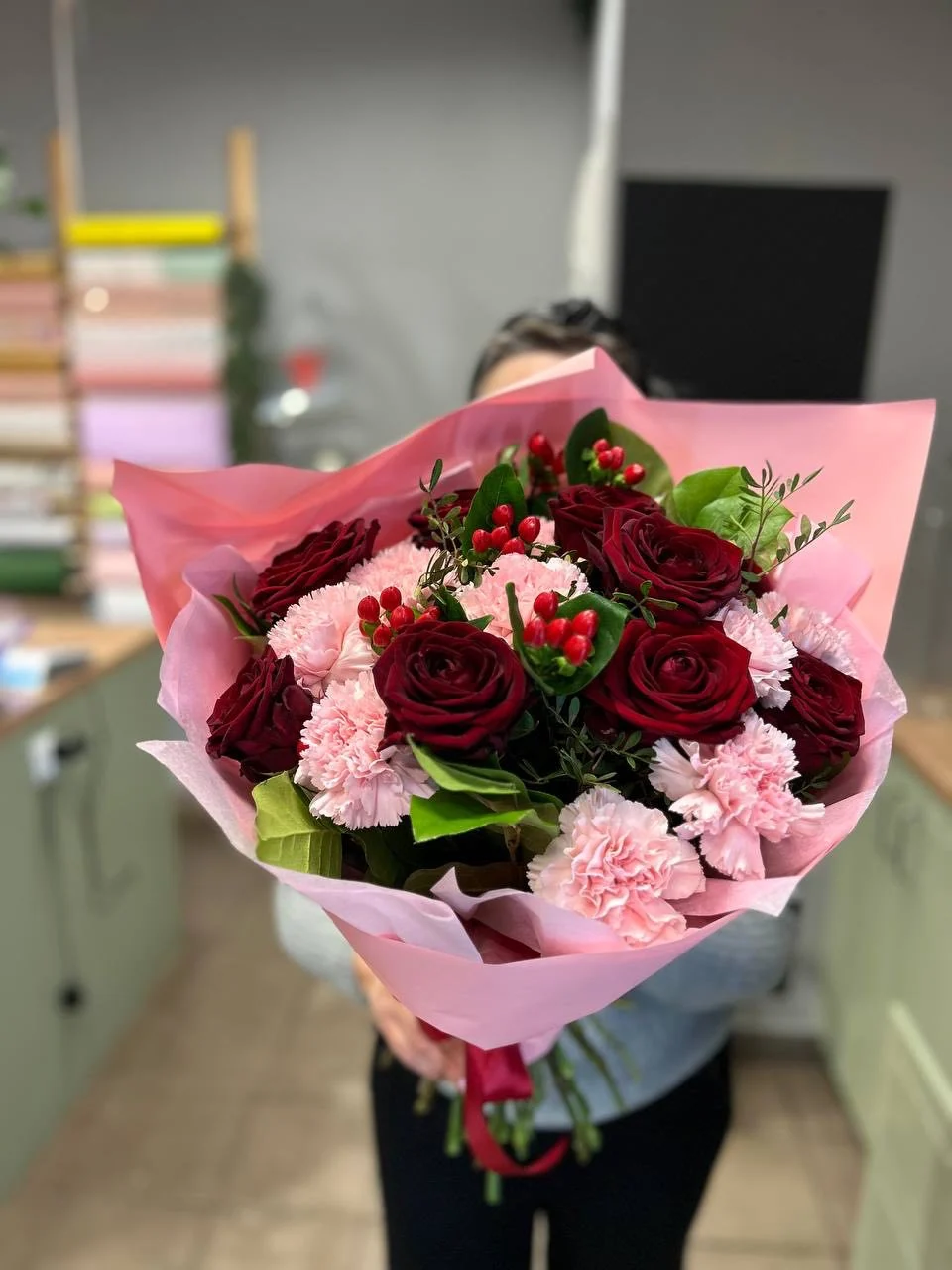 Bukiet z bordowymi różami i różowymi goździkami w różowym papierze