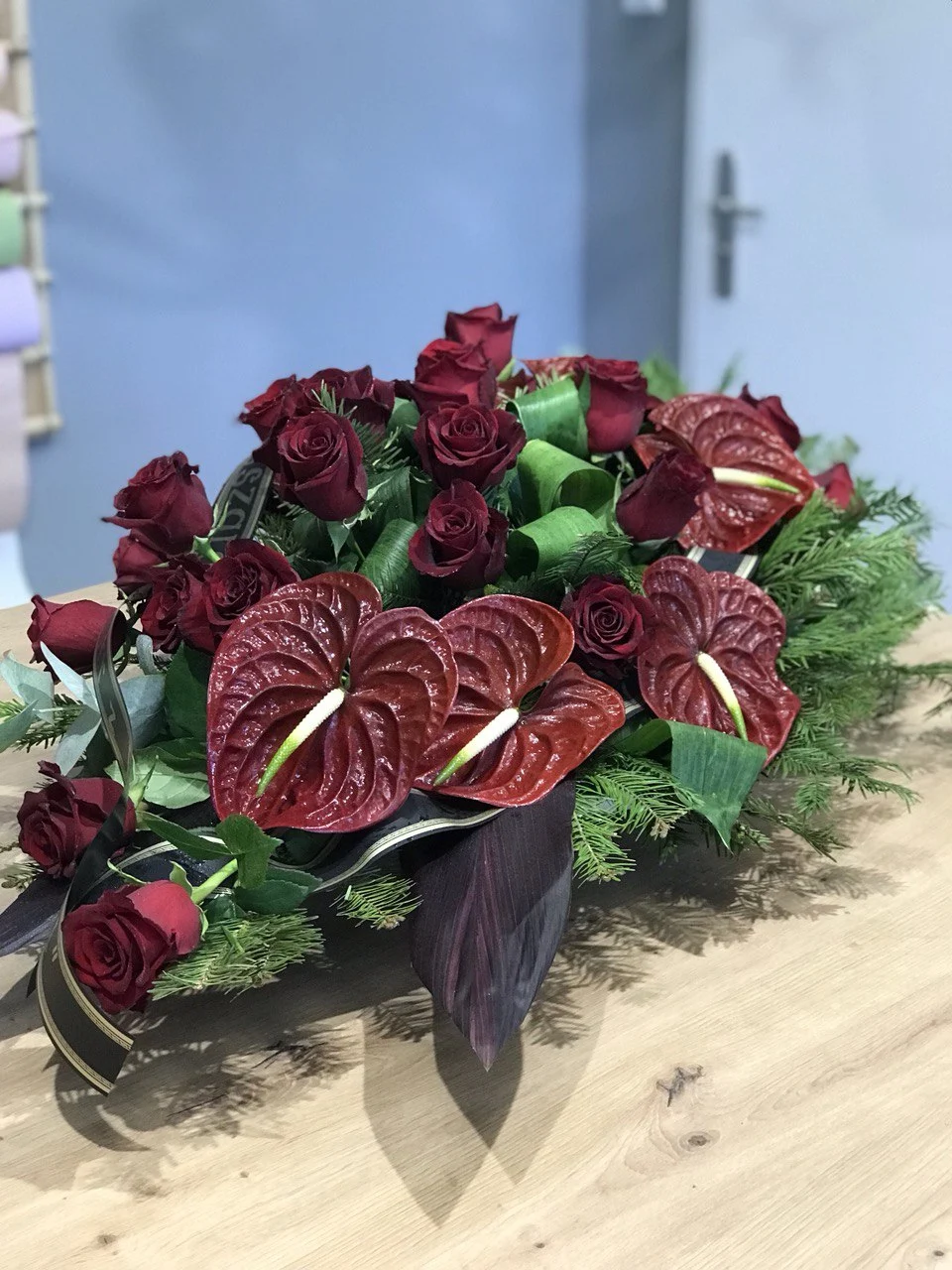 Kompozycja funeralna z bordowymi różami, anturium i zielenią