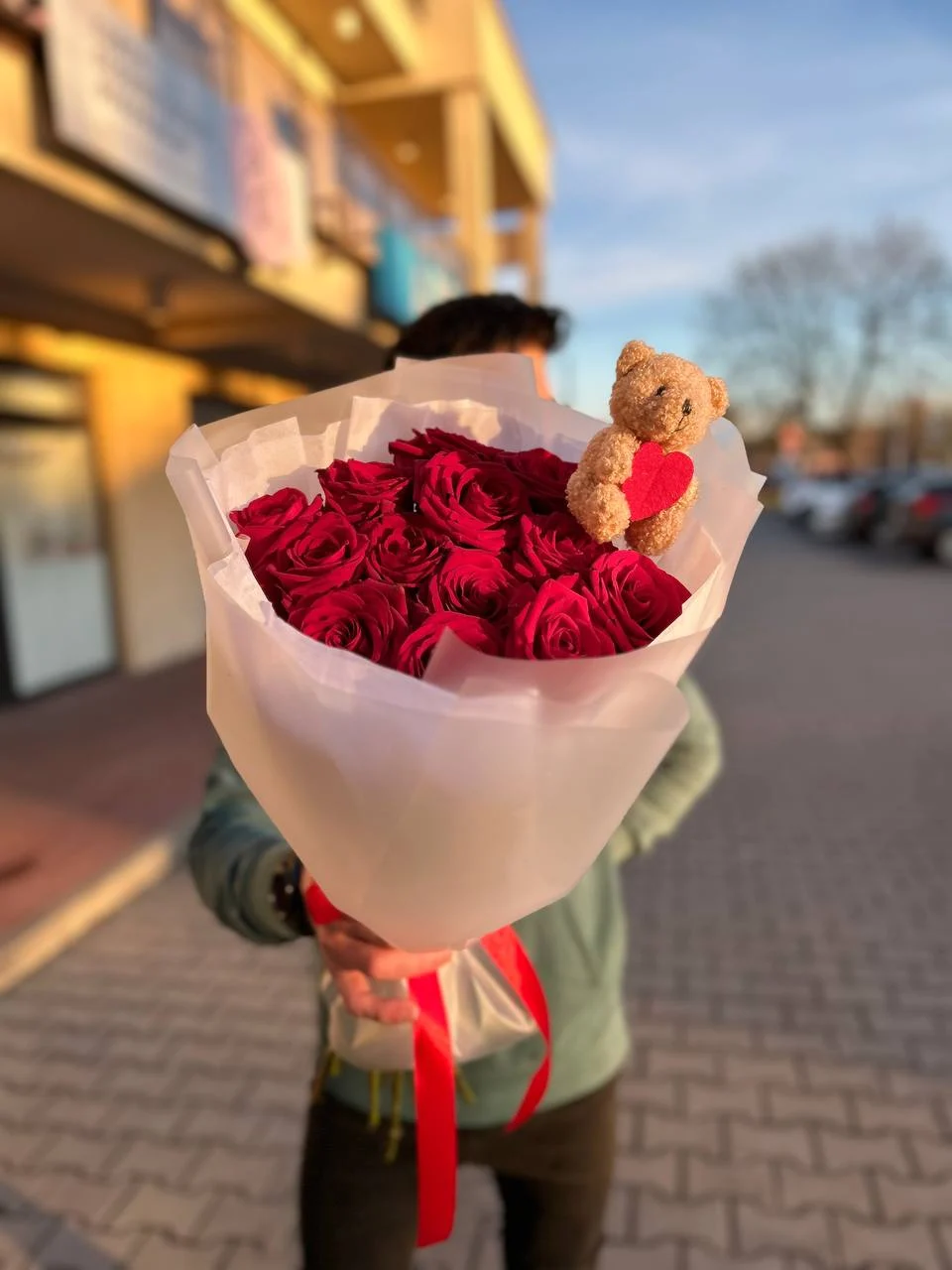 Piękny bukiet czerwonych róż ozdobiony pluszakiem w kształcie serca