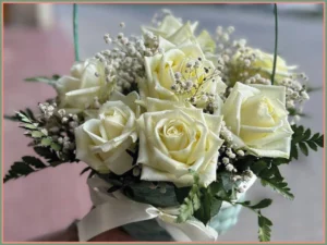 Bukiet białych róż w pudełku.