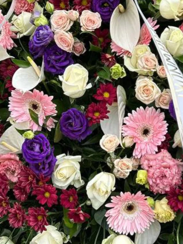 Krąg wieczności – klasyczny wieniec na pogrzeb z różami i eustomą, stojący na eleganckim stelażu