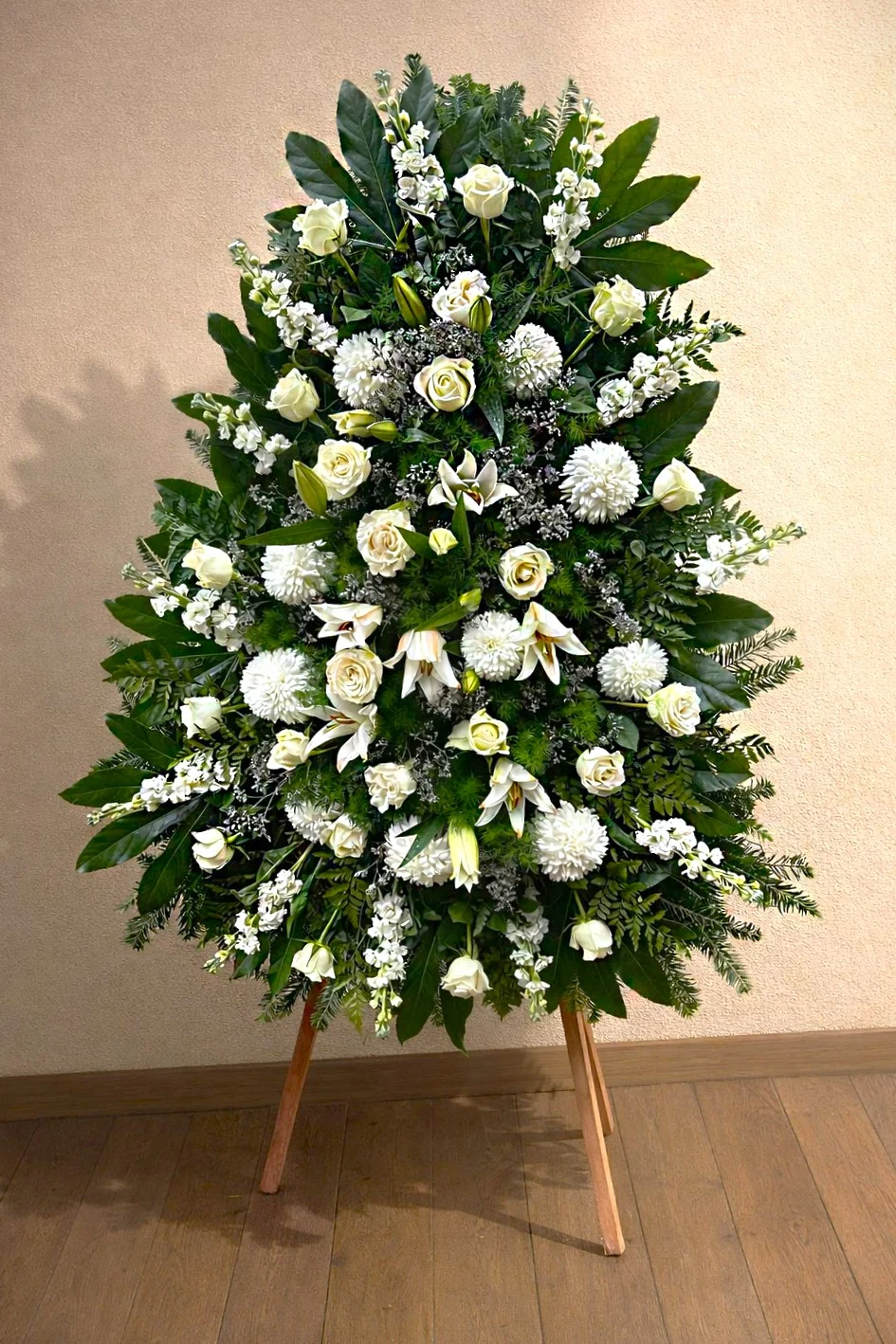 Wieniec pogrzebowy z białych kwiatów na stojaku