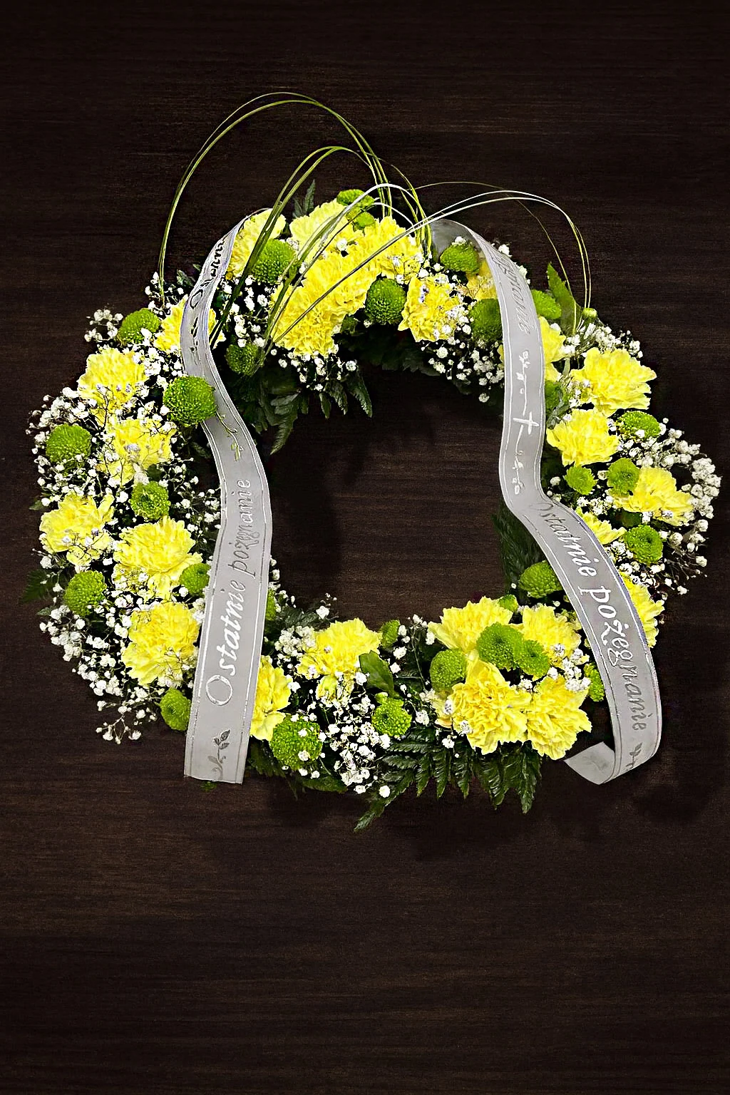 Elegancki wieniec pogrzebowy z żółtych kwiatów i gipsówki
